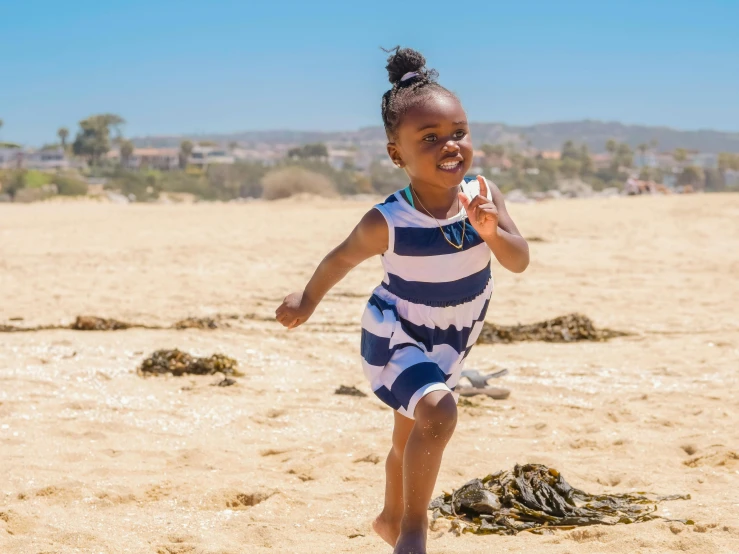 a little girl is running on the beach, by Arabella Rankin, pexels contest winner, brown skinned, clean 4 k, the city of santa barbara, doing a sassy pose