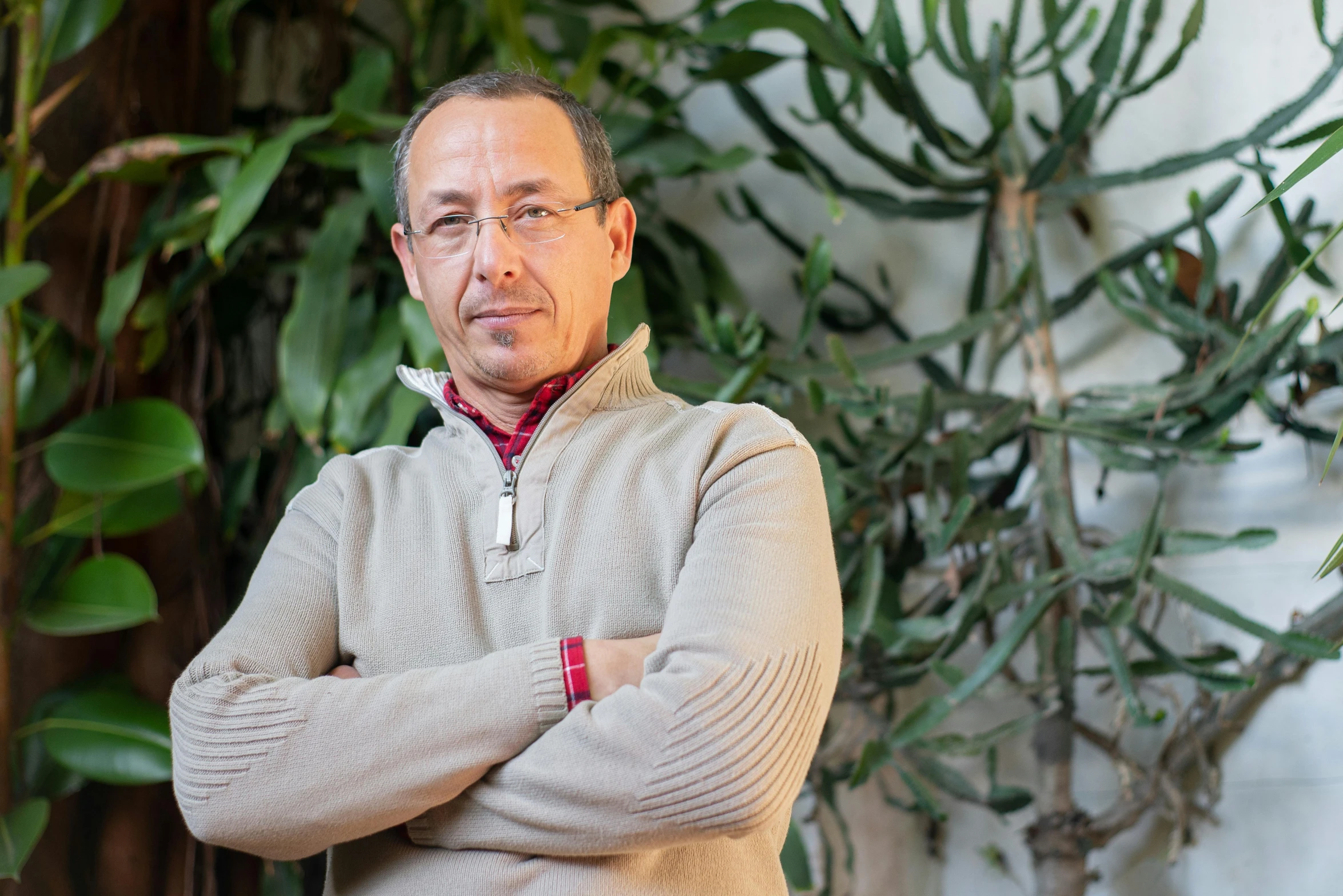 a man standing in front of a potted plant, amr elshamy, portrait image, giorgio vasari, man with glasses