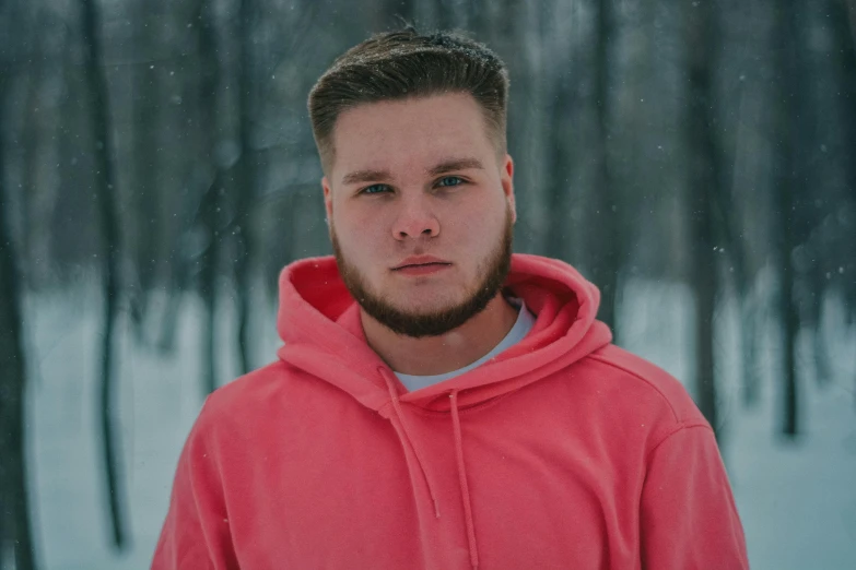 a man in a red hoodie standing in the snow, pexels contest winner, smooth pink skin, avatar image, connor hibbs, beefy