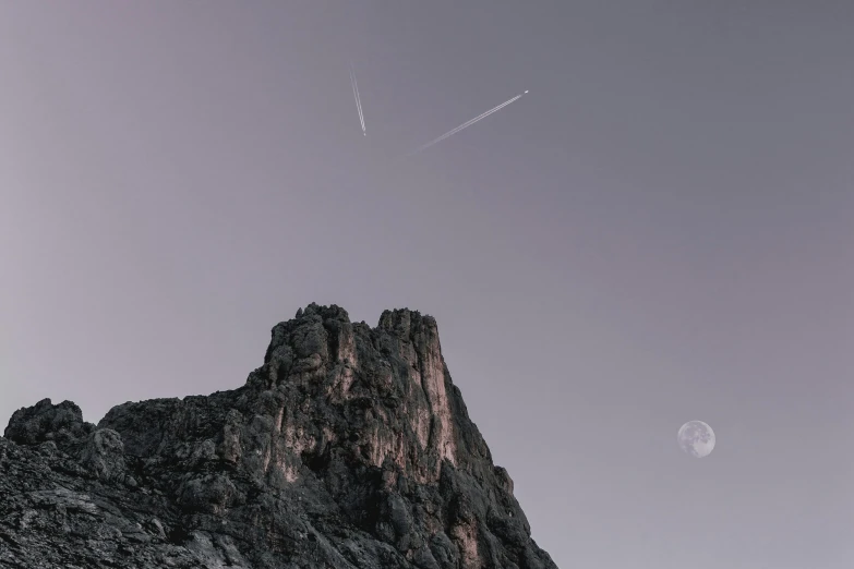 a plane flying over the top of a mountain, by Johannes Voss, pexels contest winner, postminimalism, meteors falling, moonlight grey, vertical wallpaper, missiles