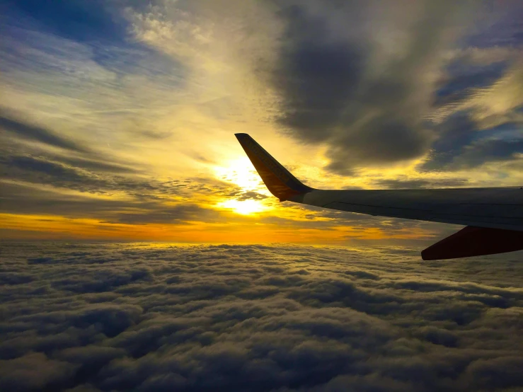the wing of an airplane flying above the clouds, by Carey Morris, pexels contest winner, sunset!, fan favorite, floating away, airplanes