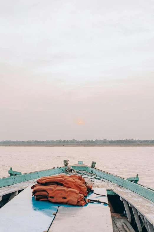 a boat sitting on top of a body of water, inspired by Steve McCurry, happening, pink sun, bangladesh, low quality photo