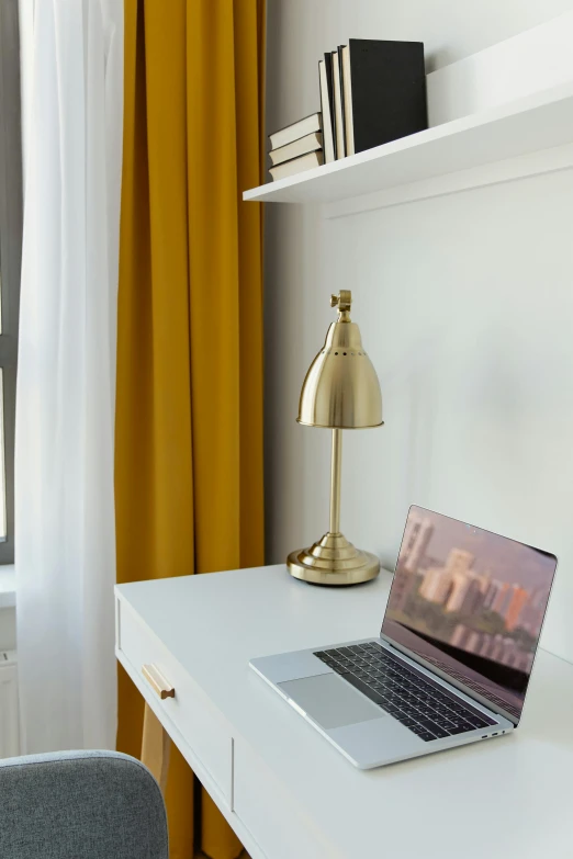 a laptop computer sitting on top of a white desk, by Nicolette Macnamara, accented in bright metallic gold, lamps, yellow windows and details, multiple stories