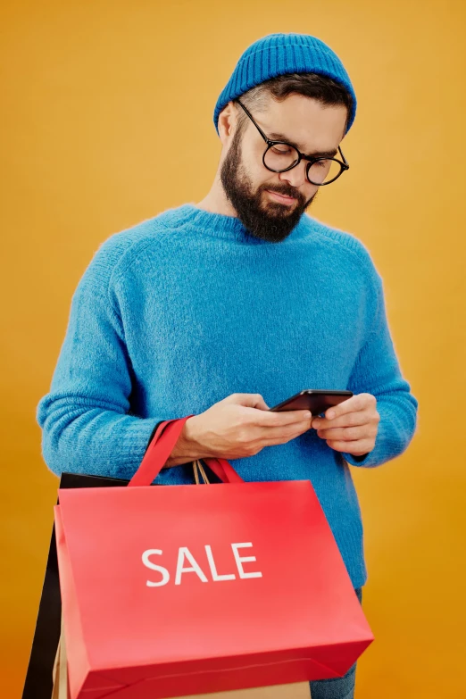 a man looking at his phone while holding a shopping bag, by Adam Saks, trending on pexels, magic realism, square rimmed glasses, blue turtleneck, sell out event, light stubble with red shirt