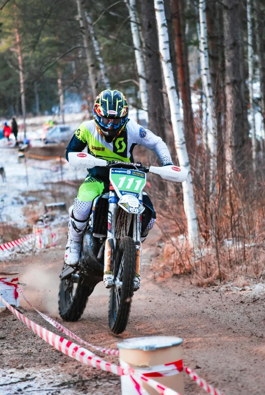 a man riding a dirt bike down a dirt road, espoo, in a race competition, in a snowy forest setting, profile image