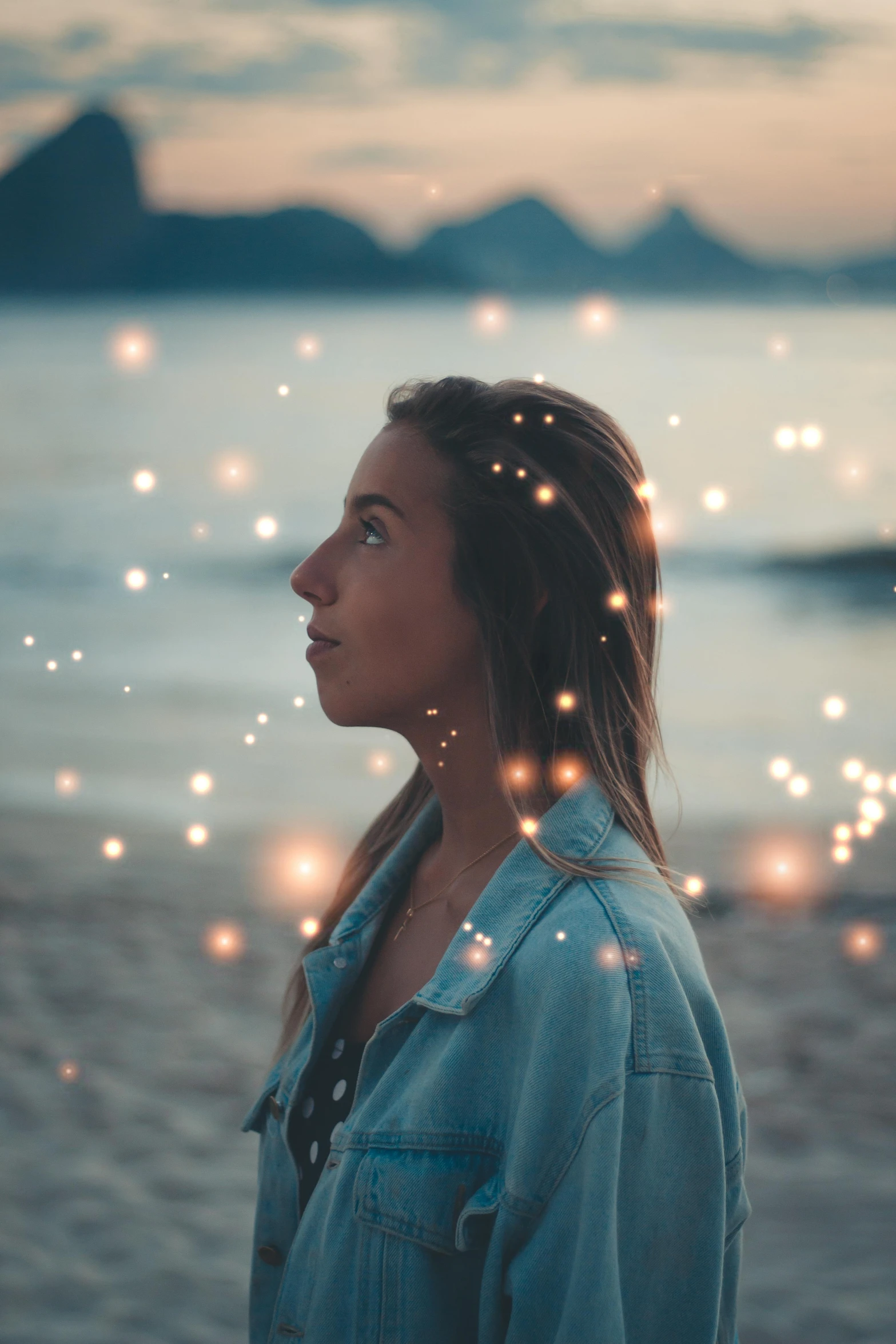 a woman standing on top of a beach next to the ocean, pexels contest winner, magical realism, blinking lights, glitter gif, backlit beautiful face, with sparking circuits