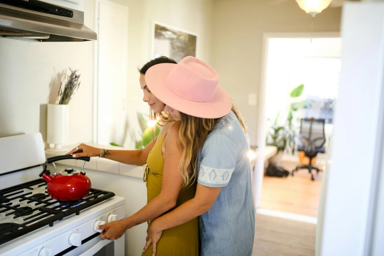 a man and a woman cooking in a kitchen, by Julia Pishtar, pexels contest winner, wearing wide sunhat, lesbian embrace, profile image, background image