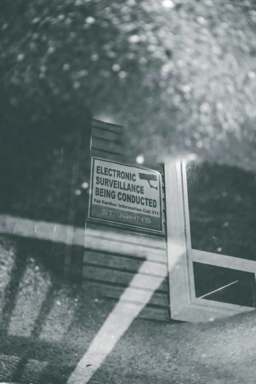 a black and white photo of a sign on the side of a building, by Daniel Lieske, unsplash, electronics see through, wet reflections in square eyes, classified government archive, an intruder