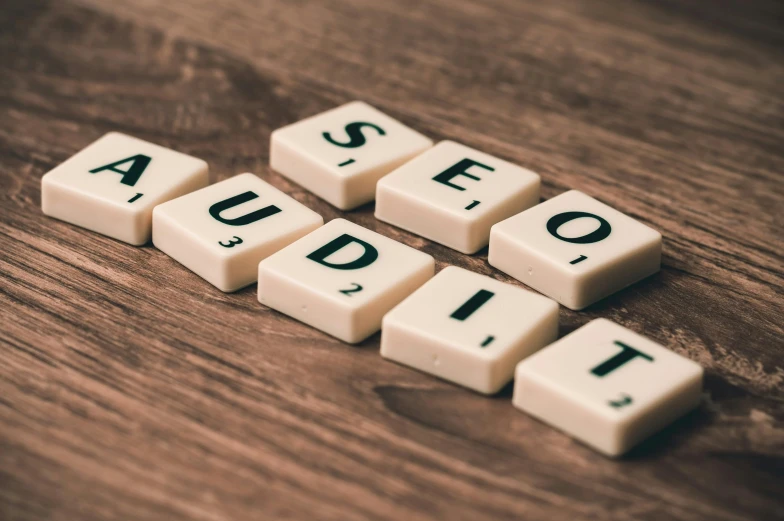 white cubes spelling seo audit on top of a wooden table, by Emma Andijewska, trending on pexels, dials, a medieval, panels, brown