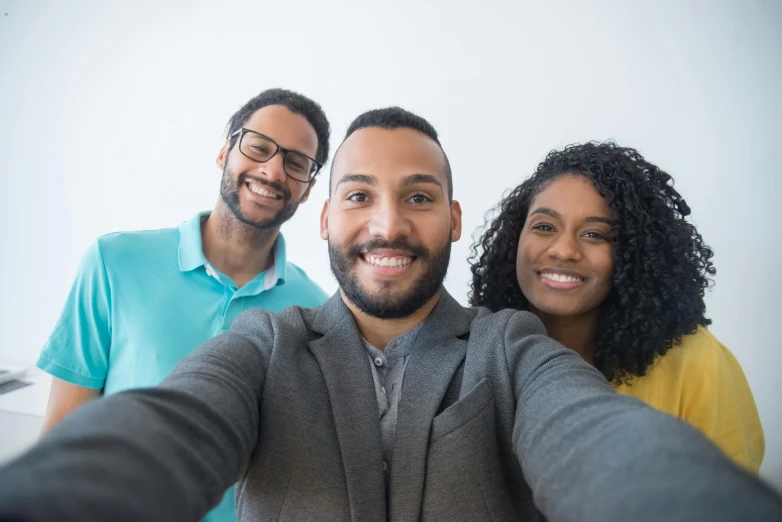 a group of people taking a selfie together, by Washington Allston, pexels contest winner, plain background, avatar image, light-brown skin, handsome