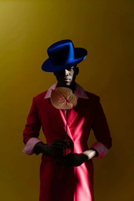 a man in a red coat and a blue hat, an album cover, inspired by Barkley Hendricks, magic realism, adut akech, award winning autochrome photo, photography of albert watson, a colorful