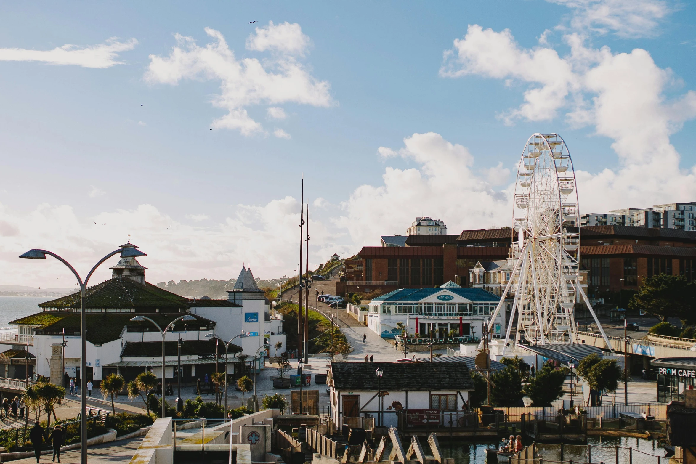 a ferris wheel sitting on top of a pier next to a body of water, by Lee Loughridge, pexels contest winner, hurufiyya, seaside victorian building, aardman studios, panoramic view, tie-dye