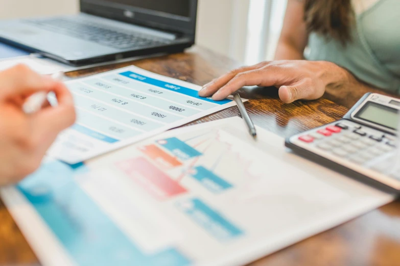 two people sitting at a table with a laptop and calculator, pexels contest winner, analytical art, loosely cropped, graphs, 🦩🪐🐞👩🏻🦳, high resolution image