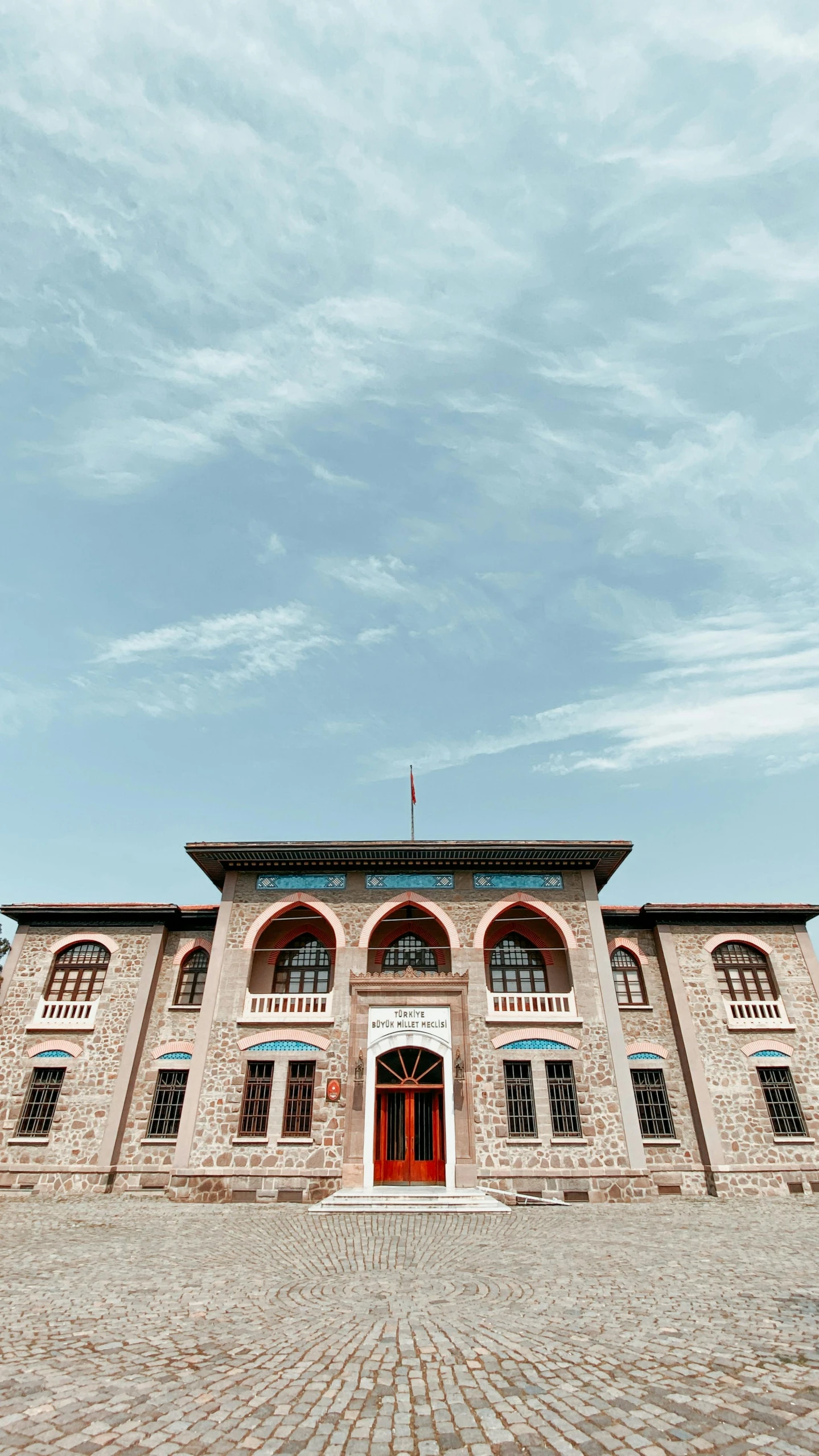 a large brick building with a red door, pexels contest winner, damascus, trending on vsco, schools, front elevation view