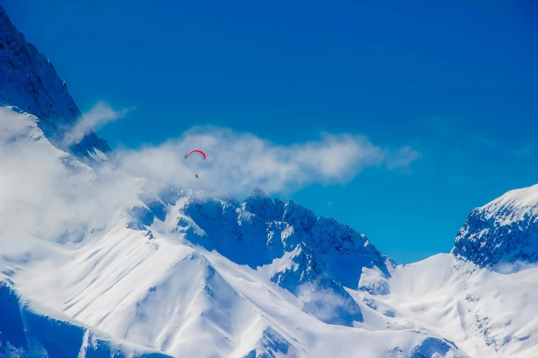 a man flying through the air while riding a snowboard, by Julia Pishtar, pexels contest winner, hurufiyya, mountain background, parachutes, lariennechan, “ aerial view of a mountain