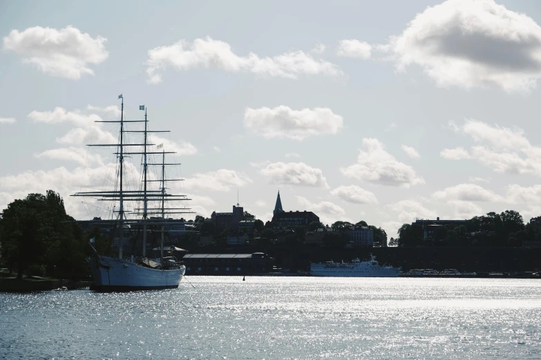 a large boat floating on top of a body of water, a photo, inspired by Wilhelm Marstrand, pexels contest winner, happening, swedish urban landscape, three masts, archimedes, round-cropped