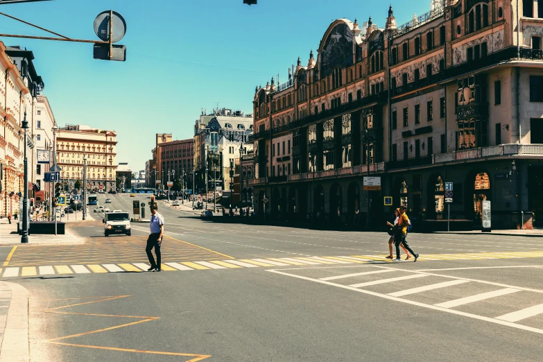 a couple of people walking across a street, pexels contest winner, socialist realism, russian architecture, intersection, very sunny, 000 — википедия