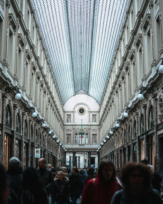 a group of people walking inside of a building, by Julia Pishtar, pexels contest winner, renaissance, lots of shops, belgium, long hall way, in the center of the image