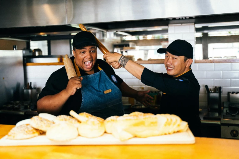 a couple of men standing next to each other in a kitchen, pexels contest winner, holding toasted brioche bun, lizzo, in an action pose, happy chef