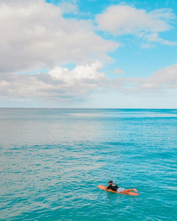 a woman laying on a surfboard in the ocean, by Robbie Trevino, pexels contest winner, minimalism, waikiki beach, rainbow tubing, azure blue sky, thumbnail