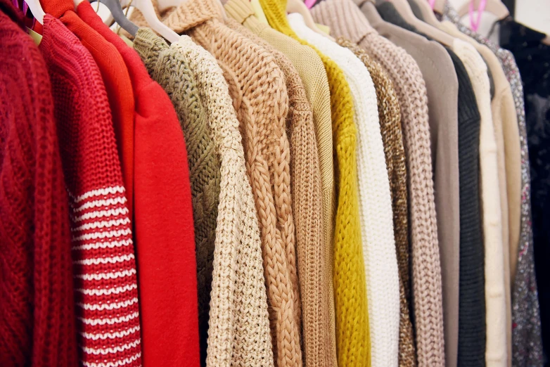 a row of sweaters hanging on a rack, a photo, trending on pexels, wearing red and yellow clothes, natural colours, 🦩🪐🐞👩🏻🦳, plus-sized