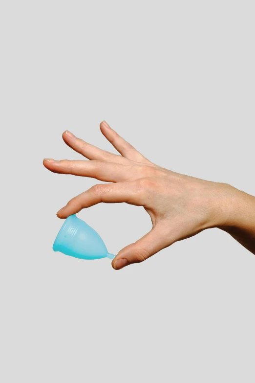 a person holding a blue object in their hand, by Rachel Reckitt, reddit, plasticien, larynx, official product photo, soft curvy shape, cone