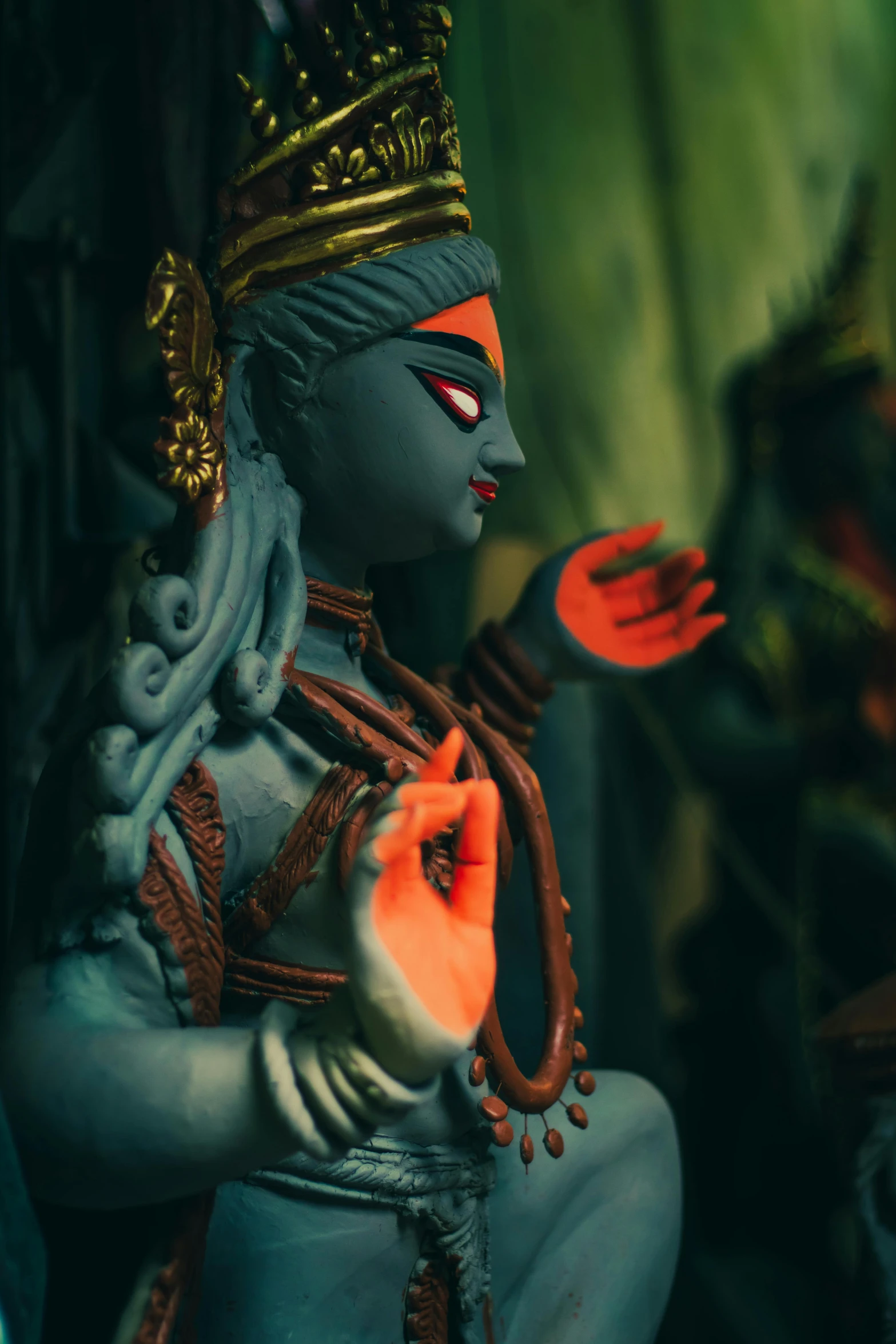 a close up of a statue of a person, anjali mudra, blue colors with red accents, claymation, highly cinematic