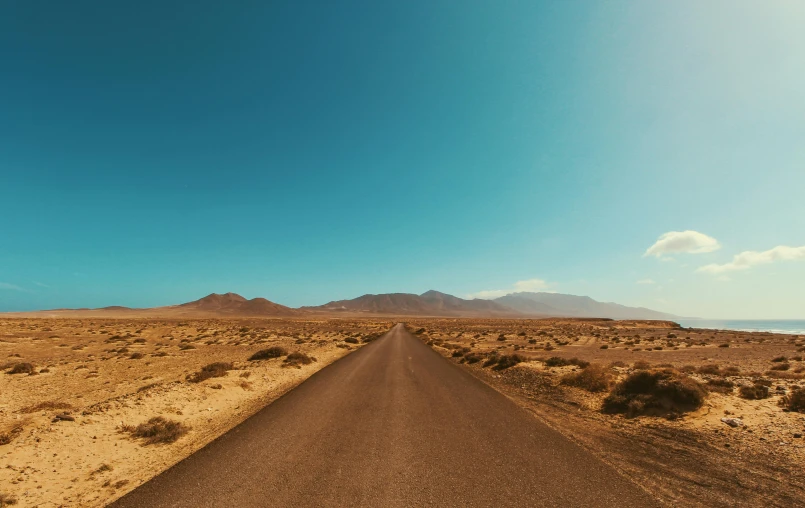 an empty road in the middle of the desert, pexels contest winner, cloudless-crear-sky, panoramic anamorphic, sunfaded, snapshot