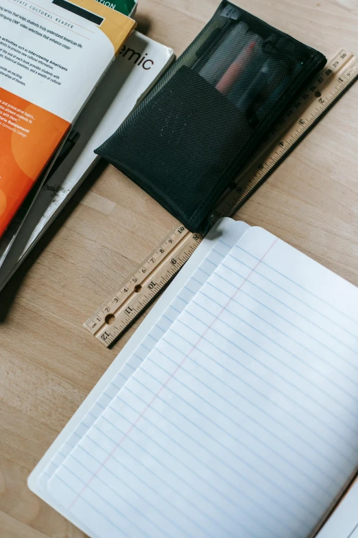 an open notebook sitting on top of a wooden table, by Carey Morris, pexels, academic art, holding scale and holding sword, photo of a classroom, high angle close up shot, low quality photo