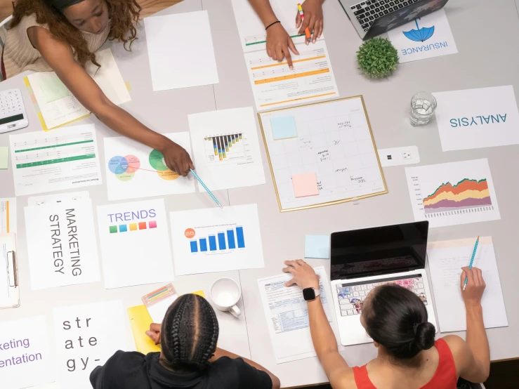 a group of people sitting around a table with laptops, trending on pexels, analytical art, whiteboards, 9 9 designs, graphic print, 1 2 9 7