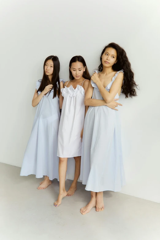 a group of young women standing next to each other, inspired by Kim Tschang Yeul, gutai group, sleepwear, light blue, frill, family friendly