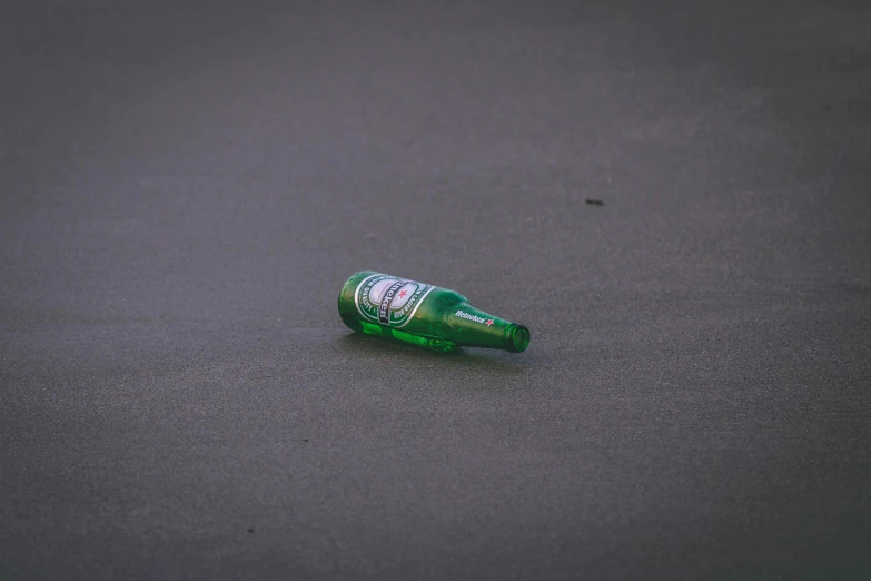 a bottle of beer laying on the ground, a picture, by Niko Henrichon, pexels, plasticien, tsunami, minimalist, sprite, drifting