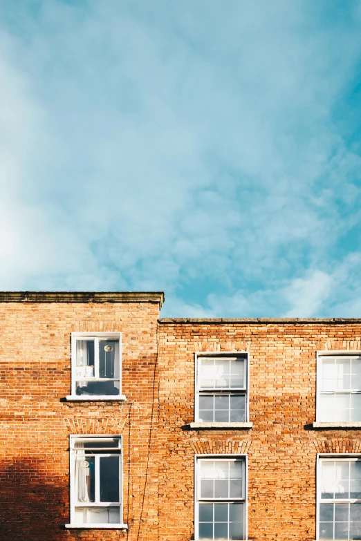 a red fire hydrant sitting in front of a tall brick building, by Rachel Reckitt, trending on unsplash, minimalism, cyan shutters on windows, 3 layers of sky above each other, taken from the high street, clouds outside the windows