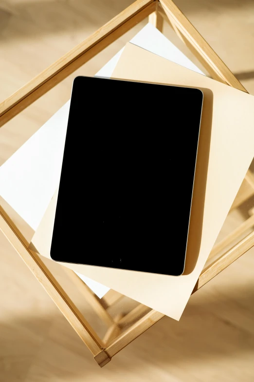 a tablet computer sitting on top of a wooden stand, unsplash, computer art, close up front view, cardboard, f / 2 0, ios