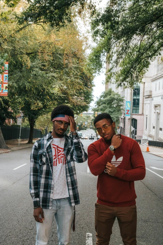 two men standing next to each other on a street, an album cover, by Washington Allston, trending on unsplash, black arts movement, cute boys, red hoods, in savannah, confident pose