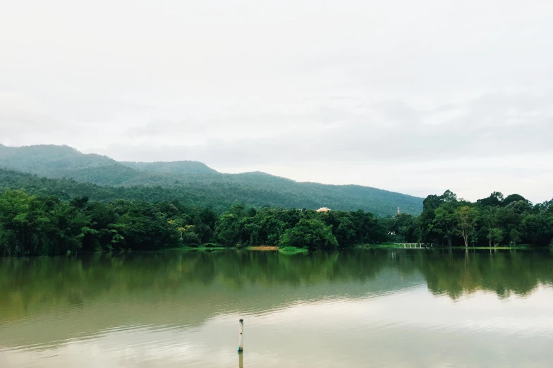 a body of water with mountains in the background, tamborine, trending on vsco, sri lanka, muted green