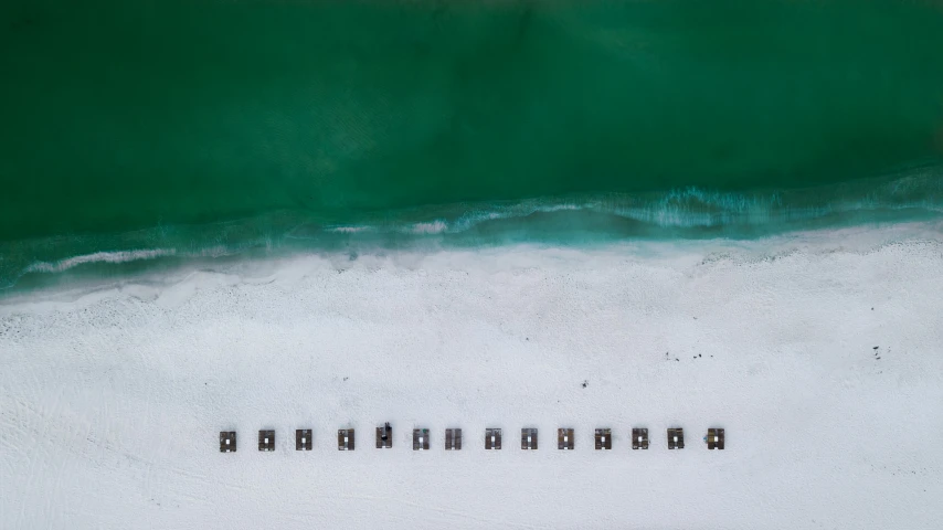 a group of people standing on top of a beach next to the ocean, inspired by Andreas Gursky, unsplash contest winner, minimalism, emerald artifacts, oil on canvas high angle view, keys, in a row