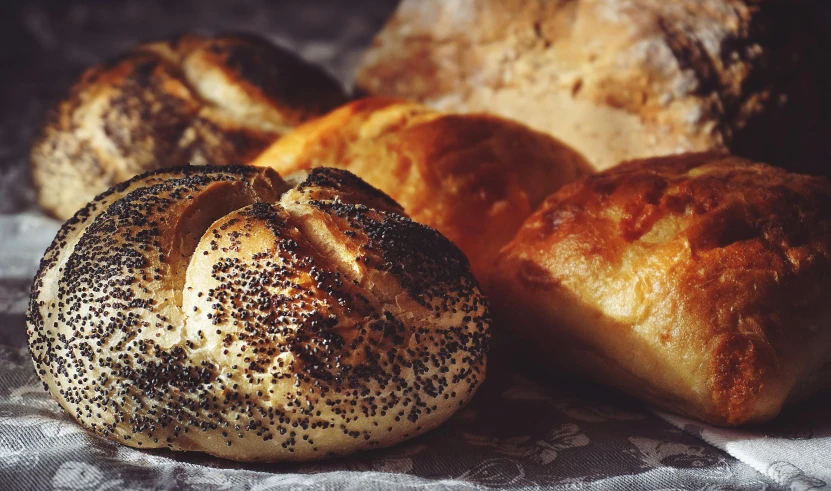 a bunch of bread sitting on top of a table, pexels contest winner, crispy buns, glittering and soft, charred, yorkshire