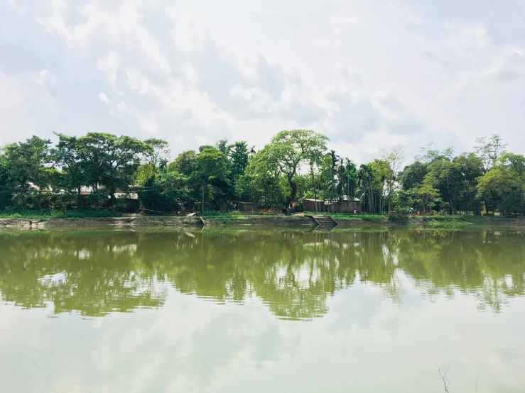 a body of water with trees in the background, hurufiyya, old dhaka, instagram photo, some green, on a bright day