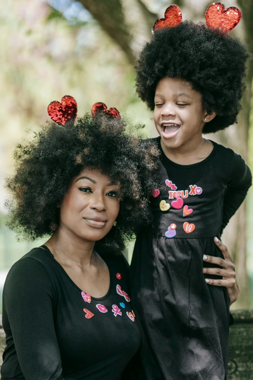 a woman and a child posing for a picture, long afro hair, red hearts, deep black roots, portrait image