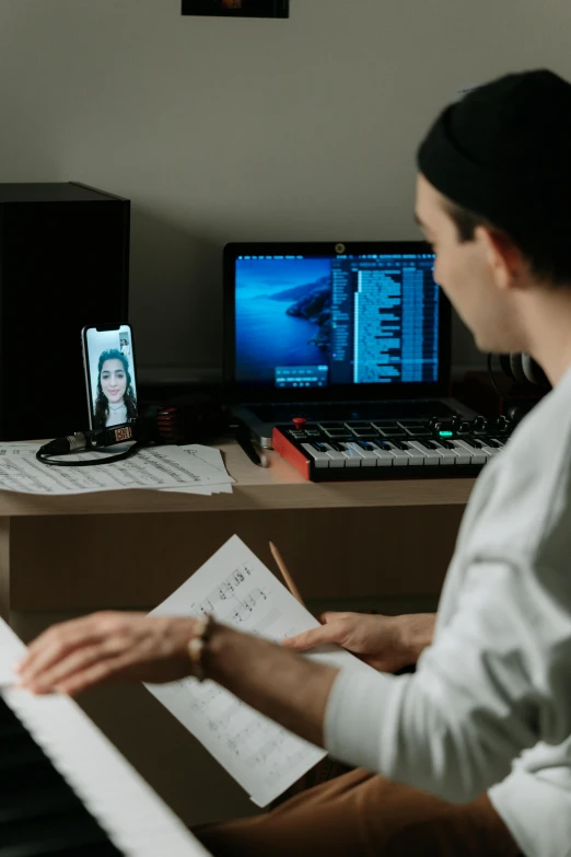 a man that is sitting in front of a keyboard, on a desk