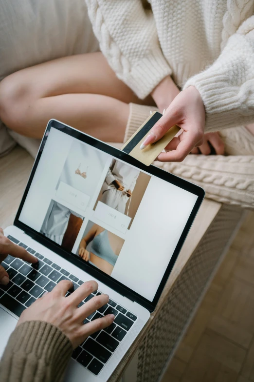 a woman sitting on a couch using a laptop computer, by Julia Pishtar, trending on pexels, renaissance, pair of keycards on table, people shopping, thumbnail, brown