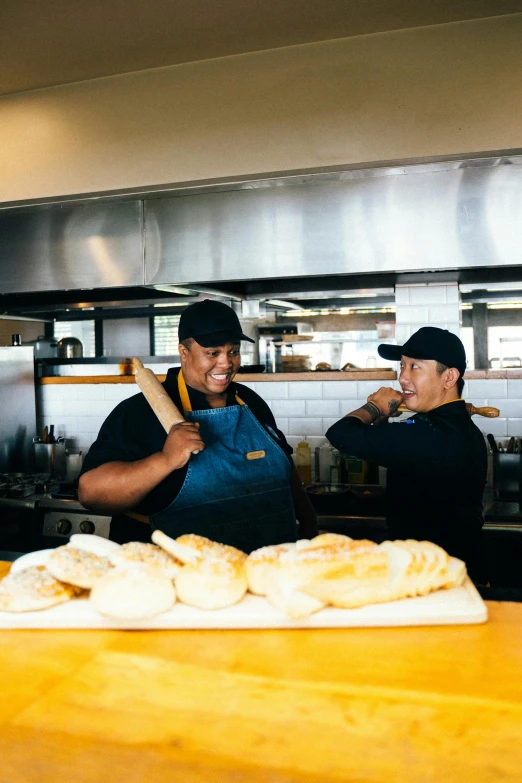 a couple of men standing next to each other in a kitchen, by Robbie Trevino, pexels contest winner, with bread in the slots, starbucks aprons and visors, a still of a happy, chilean