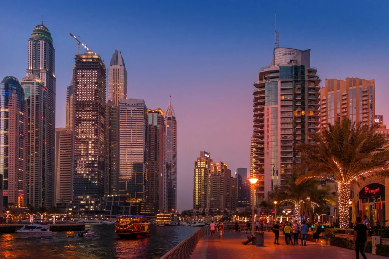a group of people walking down a sidewalk next to a body of water, pexels contest winner, hyperrealism, twilight skyline, dubai, city panorama, city of towers