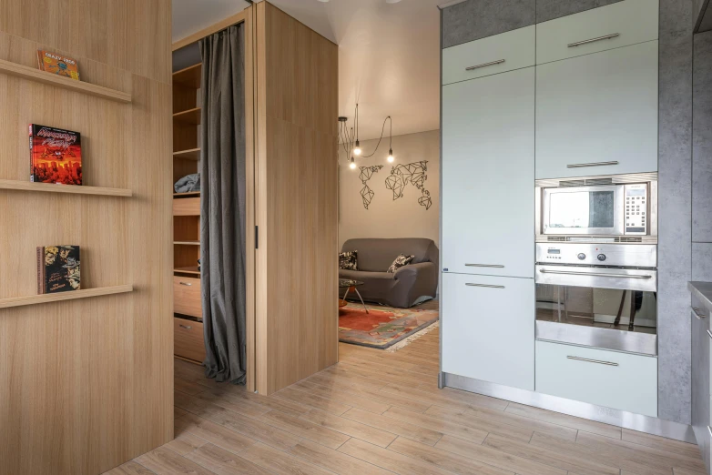 a kitchen with a stove top oven sitting on top of a wooden floor, by Adam Marczyński, light and space, two wooden wardrobes, apartment hallway, flat - color, azamat khairov