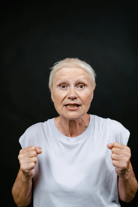 an old woman with a surprised look on her face, an album cover, pexels contest winner, showing strong muscles, wearing a tee shirt and combats, heavy gesture style closeup, ultra high face symmetry