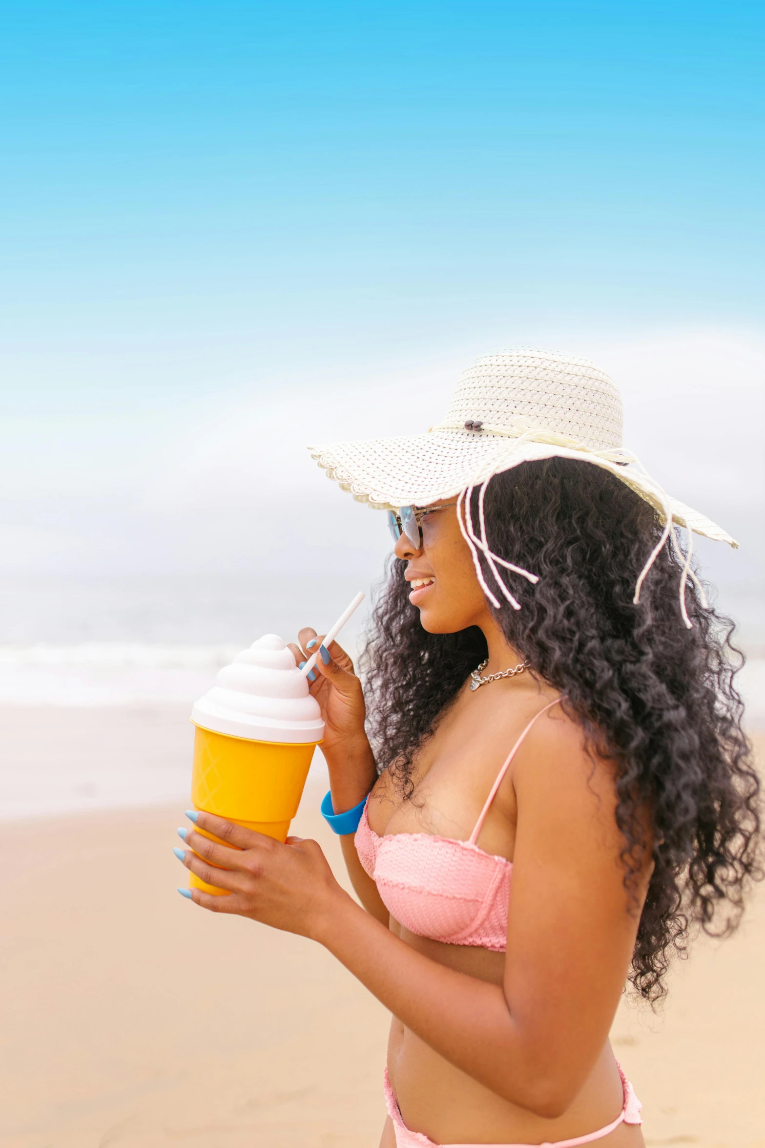 a woman in a bikini holding a beer on the beach, by Lily Delissa Joseph, trending on pexels, wavy hair yellow theme, holding a boba milky oolong tea, long afro hair, with hat