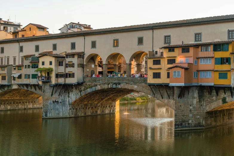 a group of people standing on a bridge over a river, by Carlo Martini, pexels contest winner, renaissance, sweeping arches, late summer evening, donatello, a quaint