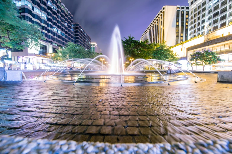 a fountain in the middle of a city at night, square, thumbnail, fan favorite, manchester