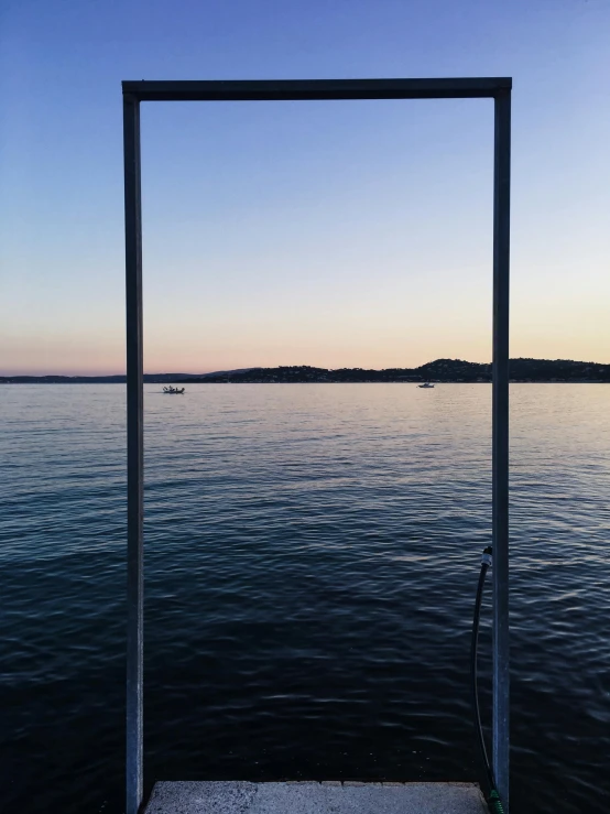 a view of a body of water with a boat in the distance, in a frame, in the evening, clear glass wall, instagram picture